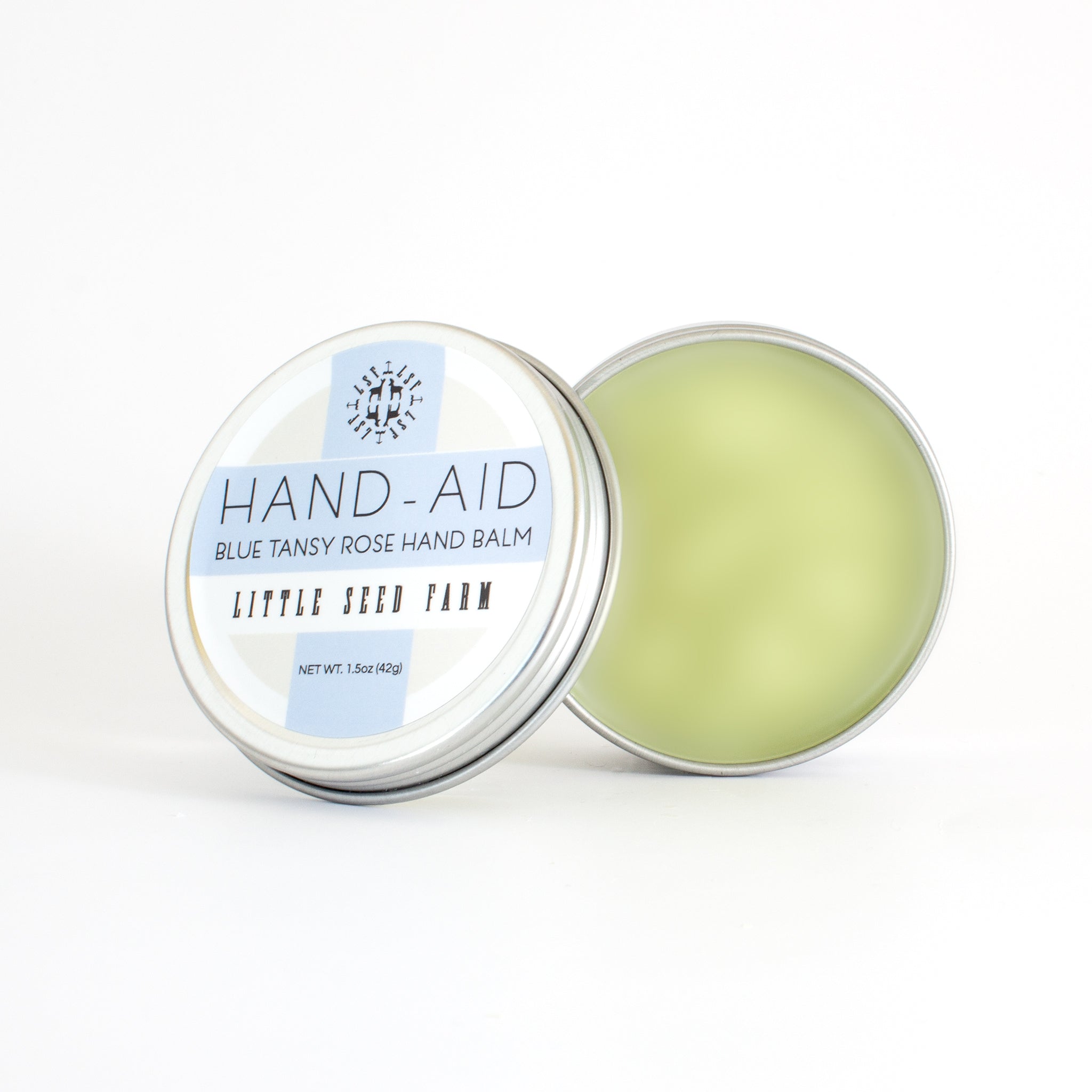Blue Tansy Rose Hand‑Aid Healing Hand Balm featuring a crisp floral scent of delicate rose and calming blue tansy, crafted with organic shea butter, hemp seed oil, and crafted with antioxidant-rich botanicals to deeply soothe dry, cracked hands.