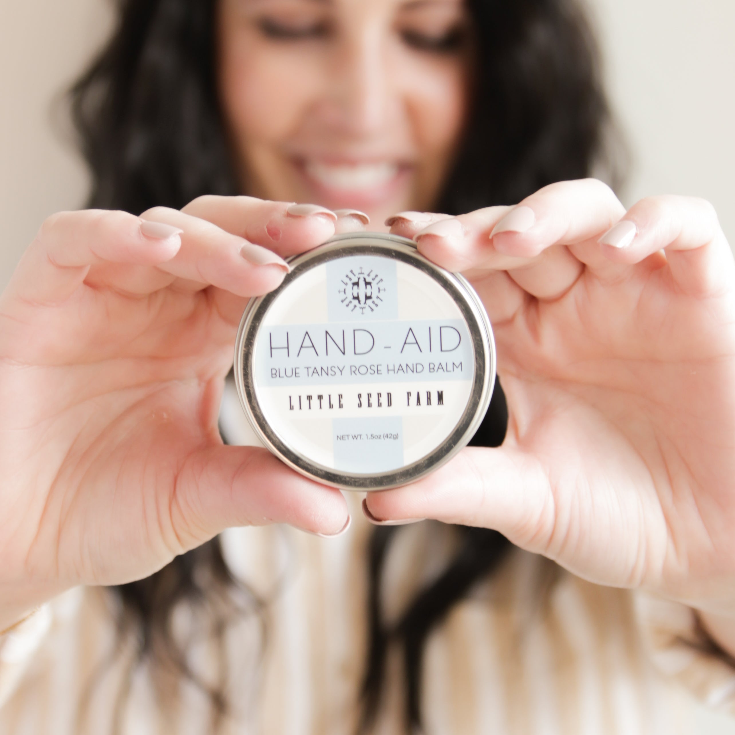 Blue Tansy Rose Hand‑Aid hand balm held in hand, showcasing its portable and nourishing design perfect for on-the-go relief and hydration for sensitive or dry skin.