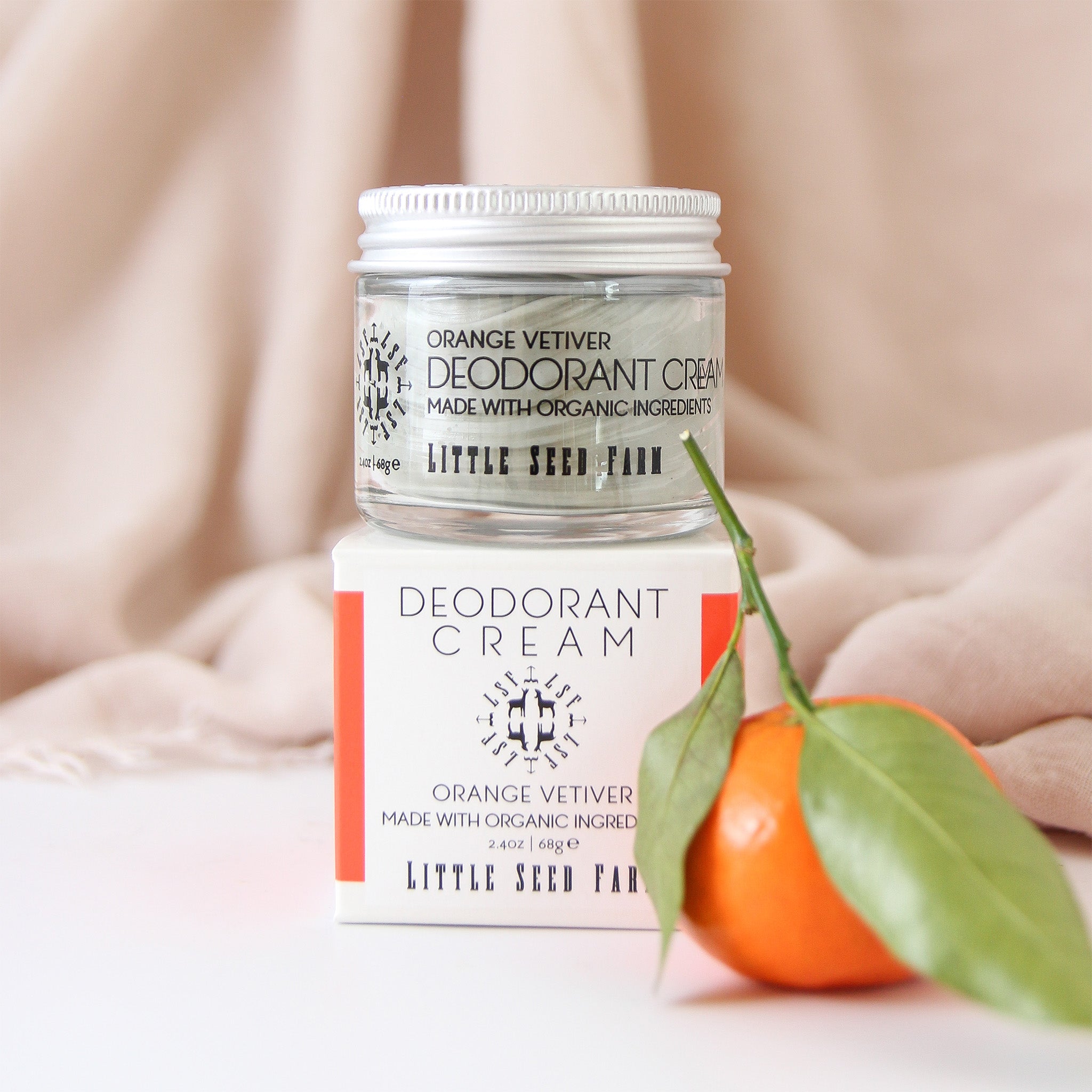 Glass jar of Orange Vetiver deodorant cream made with organic jojoba, beeswax, sweet orange oil, vetiver root oil, and activated charcoal for 24‑hour odor defense