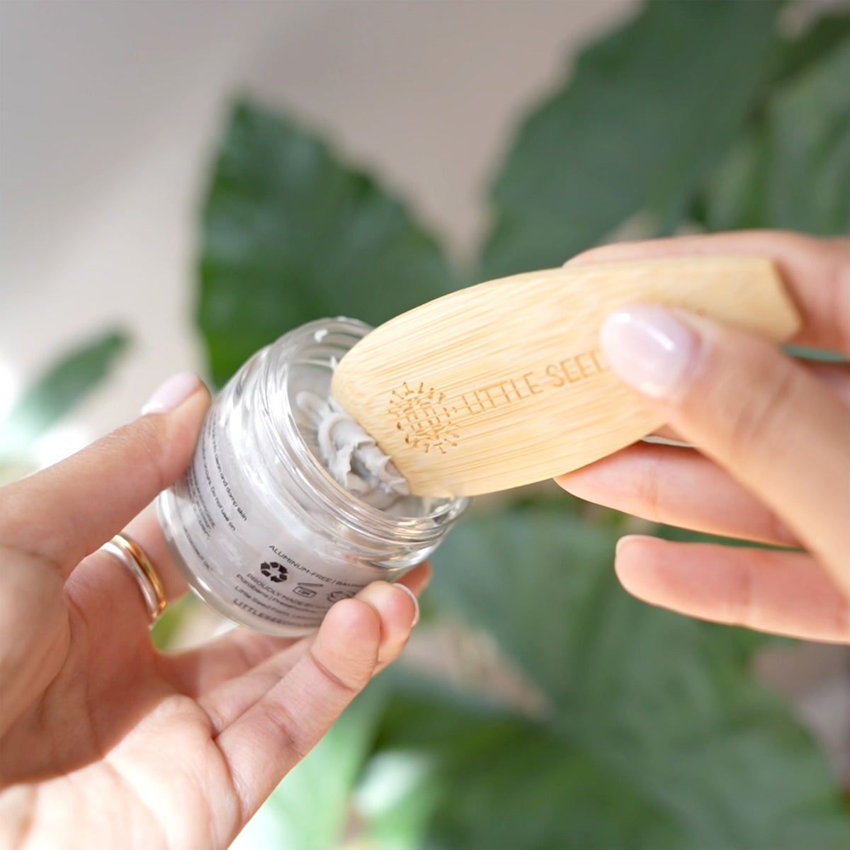 hands using the little seed farm deodorant applicator to scoop deodorant.