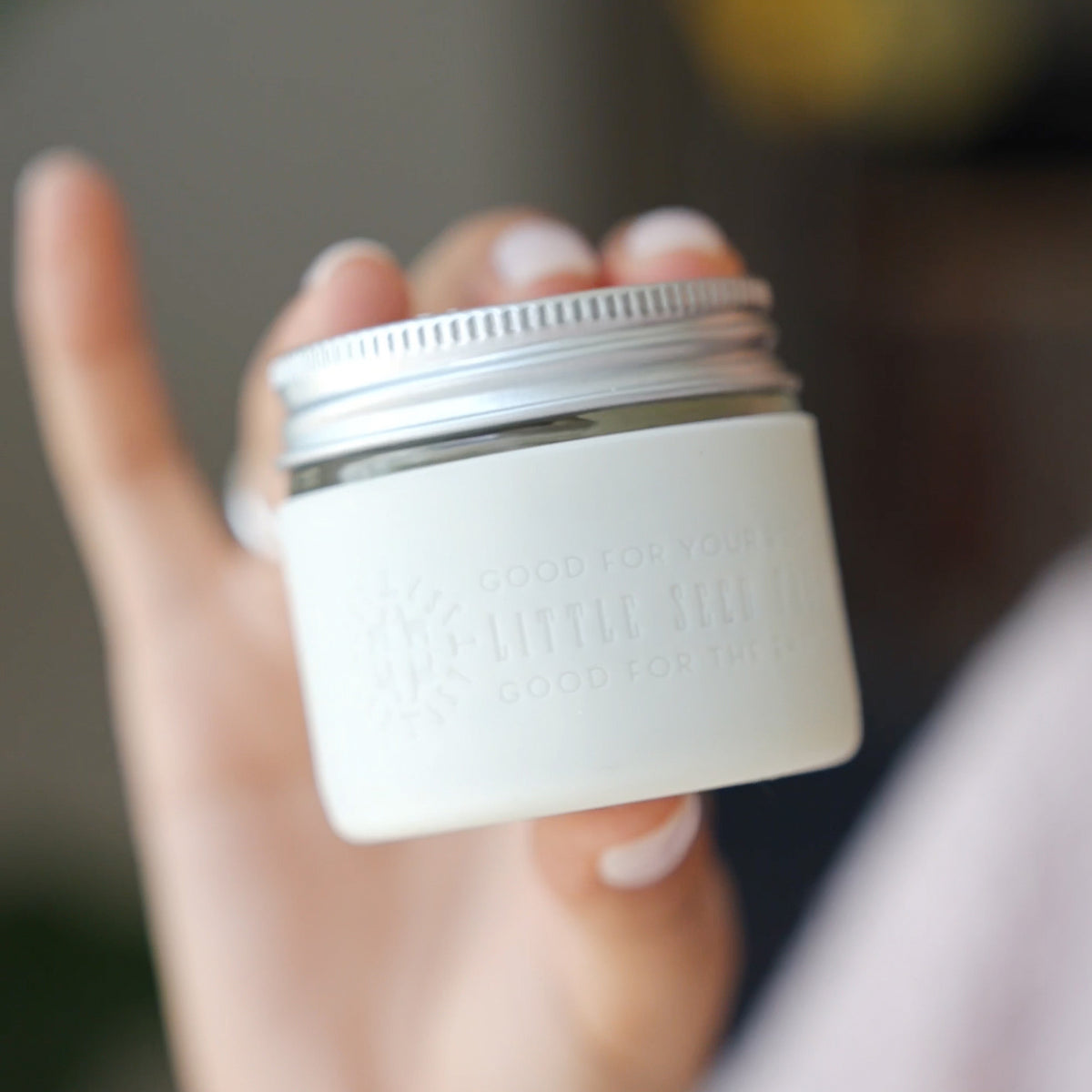 A jar of little seed farm deodorant with the white silicone sleeve with little seed farm branding.