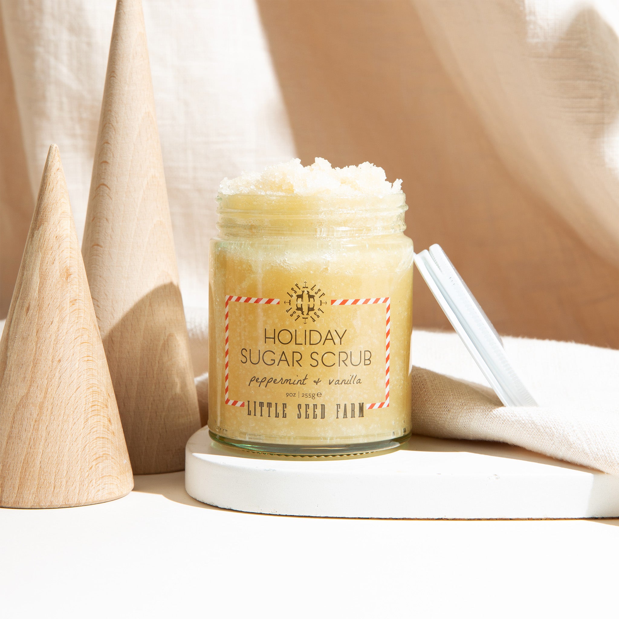 an open jar of little seed farm holiday sugar scrub.