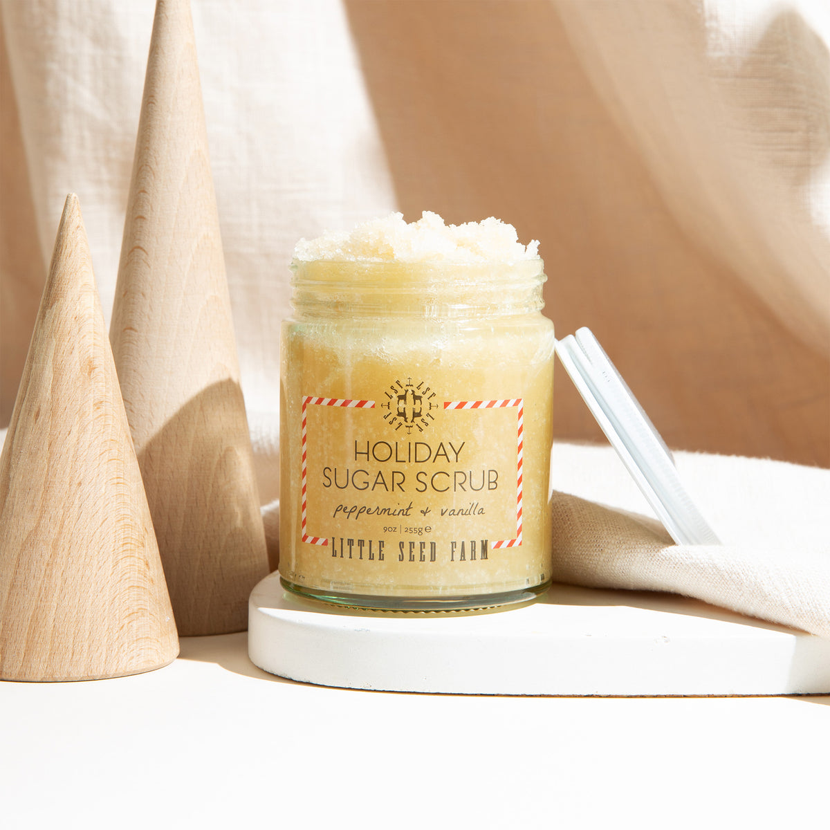an open jar of little seed farm holiday sugar scrub.