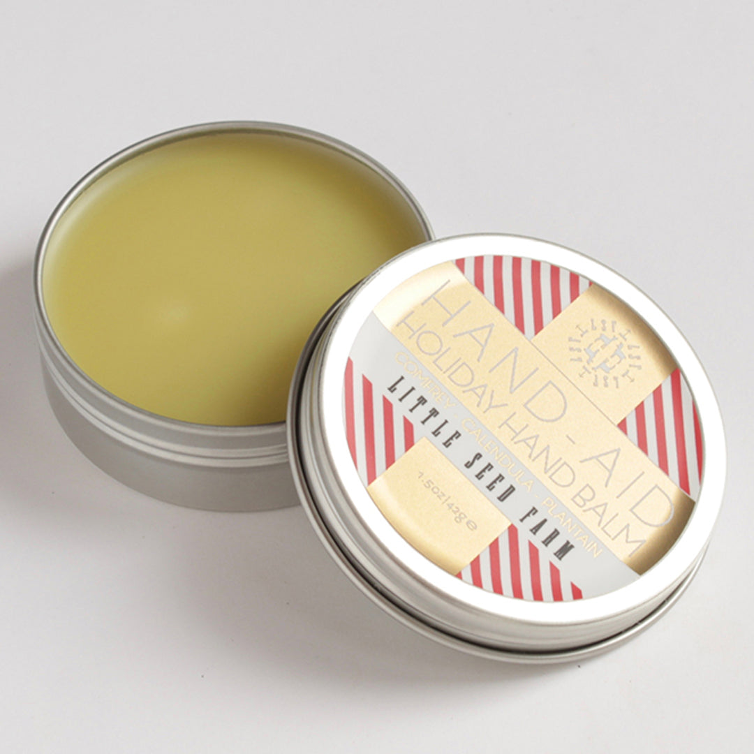 A tin of little seed farm holiday hand aid laying open.