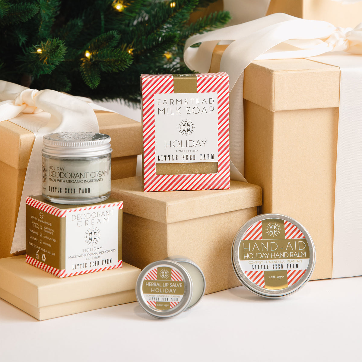 The little seed farm holiday deodorant, goats milk soap, herbal lip salve, and hand aid sitting on gift boxes.