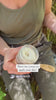 Person holding jar and applying unscented deodorant cream onto skin, demonstrating how to use it